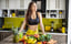 一个素食运动员站在厨房桌子上的水果前