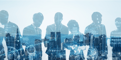 Several people in business attire having a business discussion reflected on a window, with the backdrop of an urban skyline.