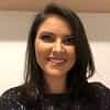 Foto Natália com uma parede neutra ao fundo