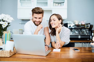 couple in front of a laptop talking 