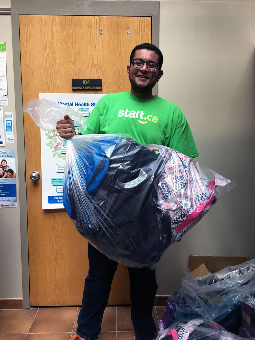 smiling employee packing backpacks for Supplies for Students