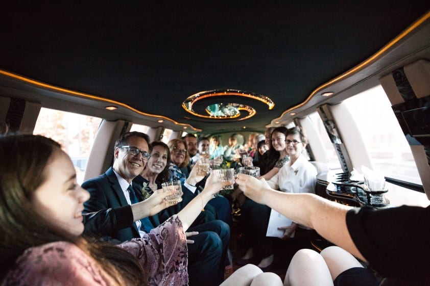 fun wedding in a limo where they're enjoying the event process