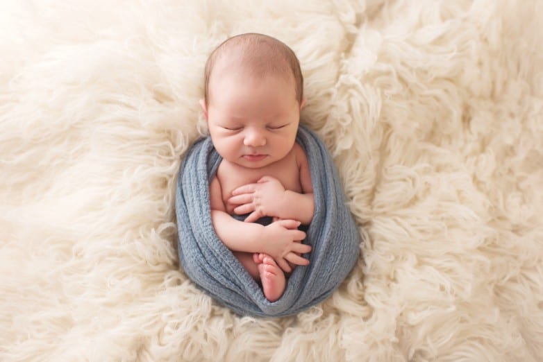 newborn baby photo half swaddled on flokati