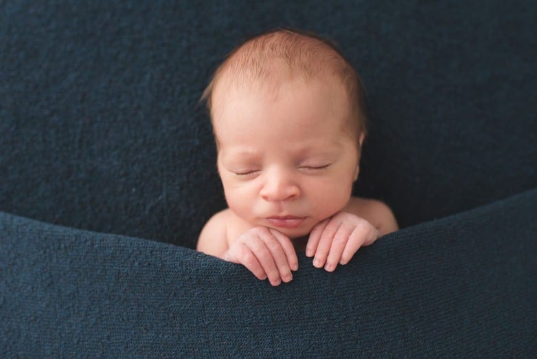 newborn baby photo posed under a blanket