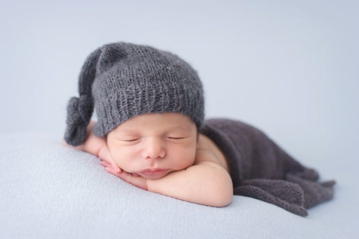 newborn baby photo with baby posed with chin on arms