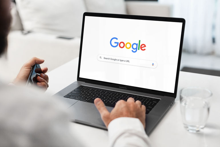 Someone searching on Google on a laptop