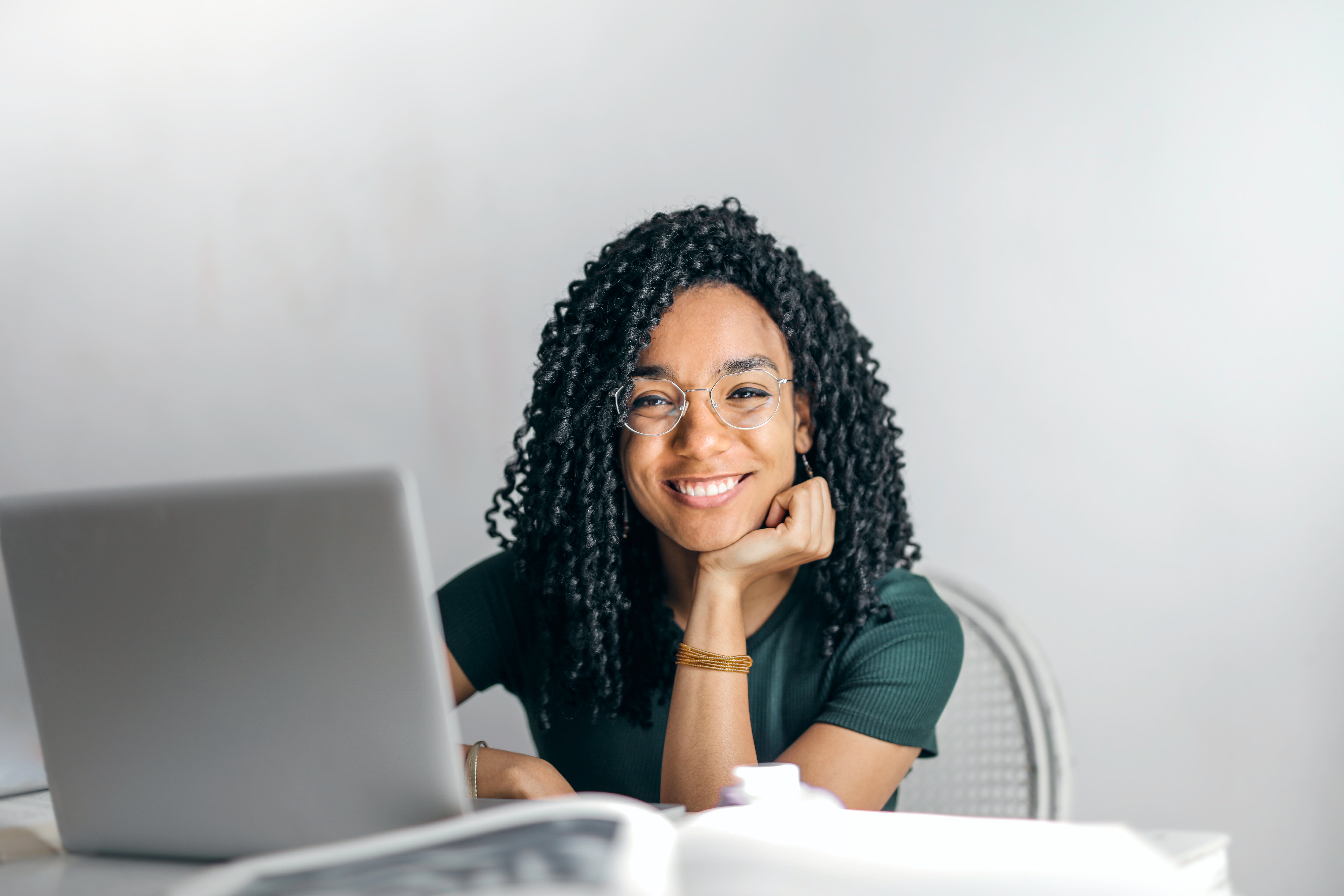 happy-ethnic-woman-sitting-at-table-with-laptop-3769021