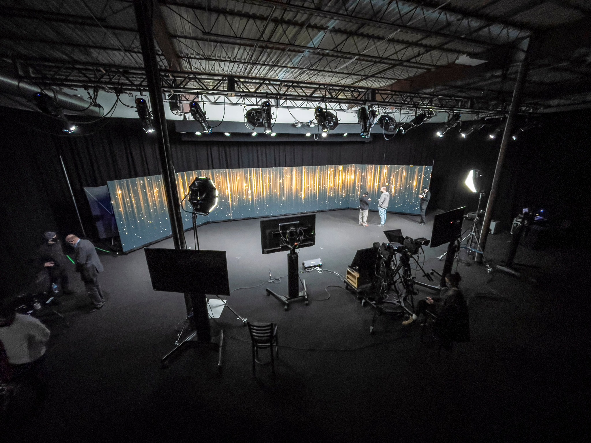 a hybrid events stage with teleprompters and video recording equipment