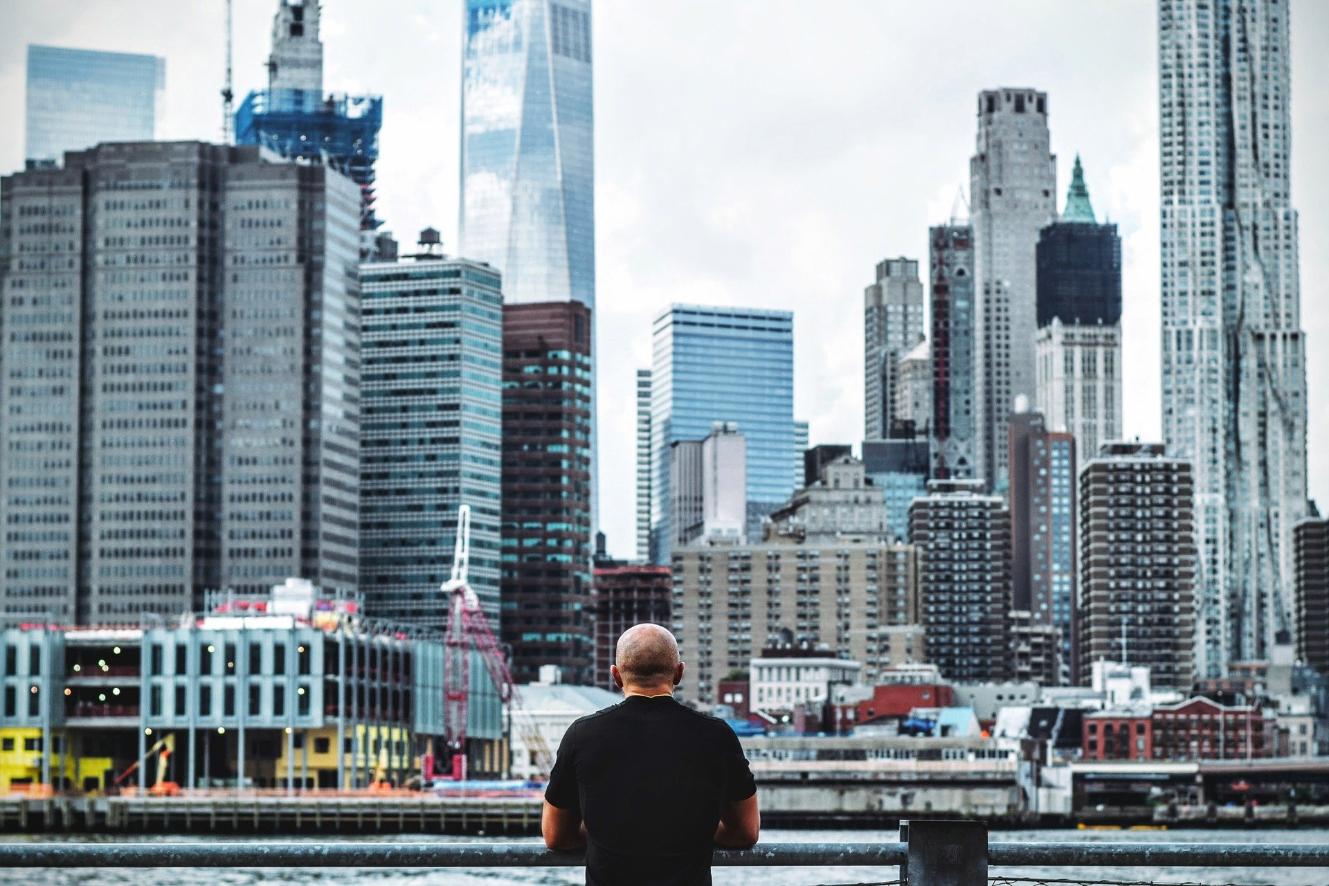 man looking out into a city