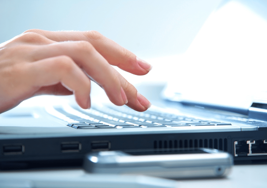 Hands typing on a computer keyboard