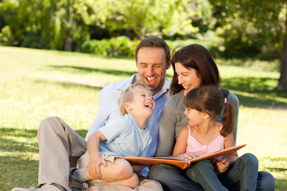 Family looking at their photo album in the park