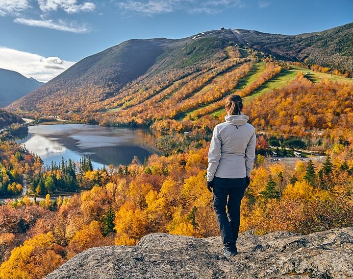 Person hiking looking at lake in Fall
