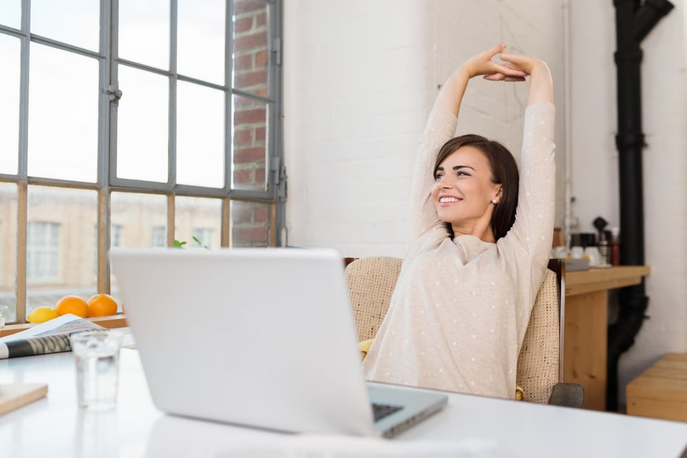 Mitarbeiterin macht kurze Pause am Arbeitsplatz