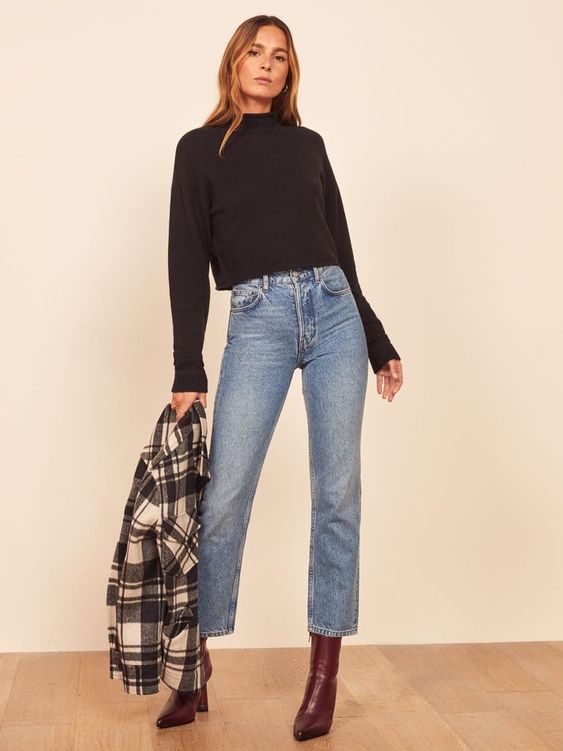 Woman wearing black turtleneck and cropped jeans