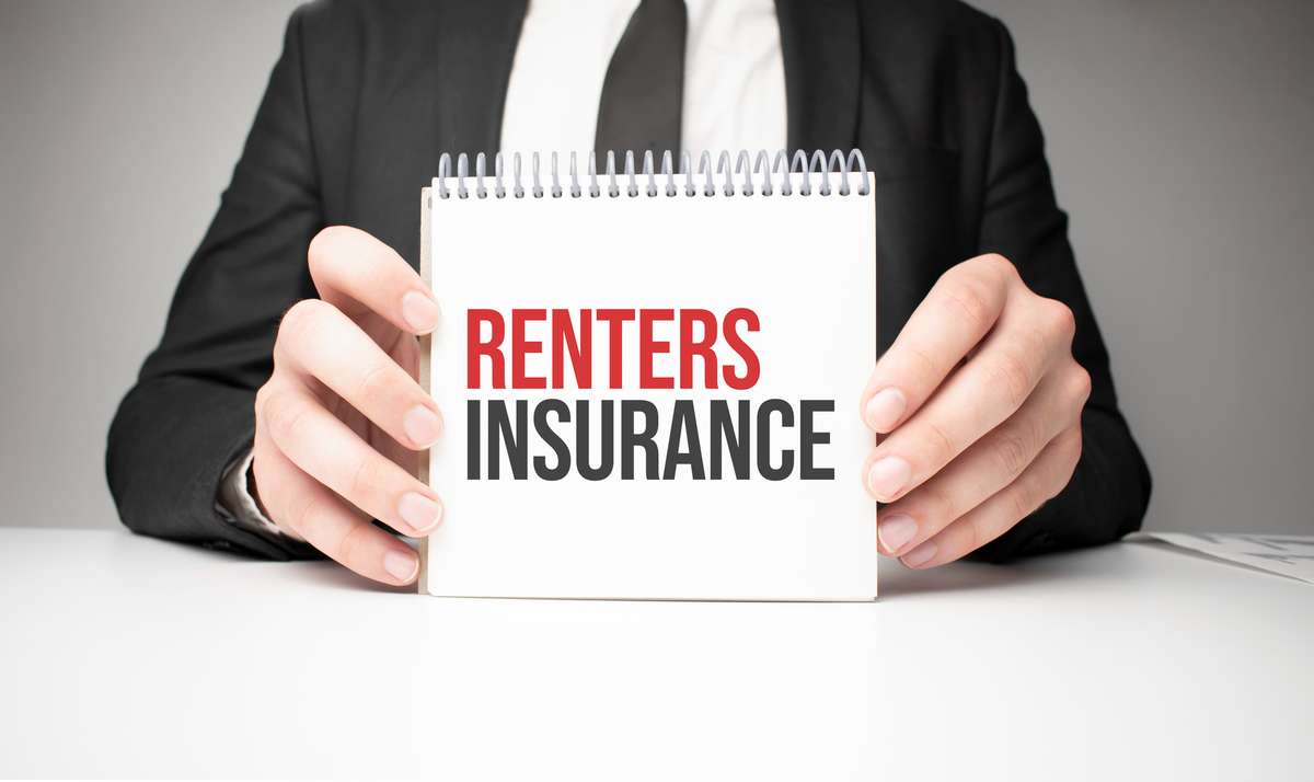 Businessman holding sheet of paper with a message Renters insurance (R) (S)