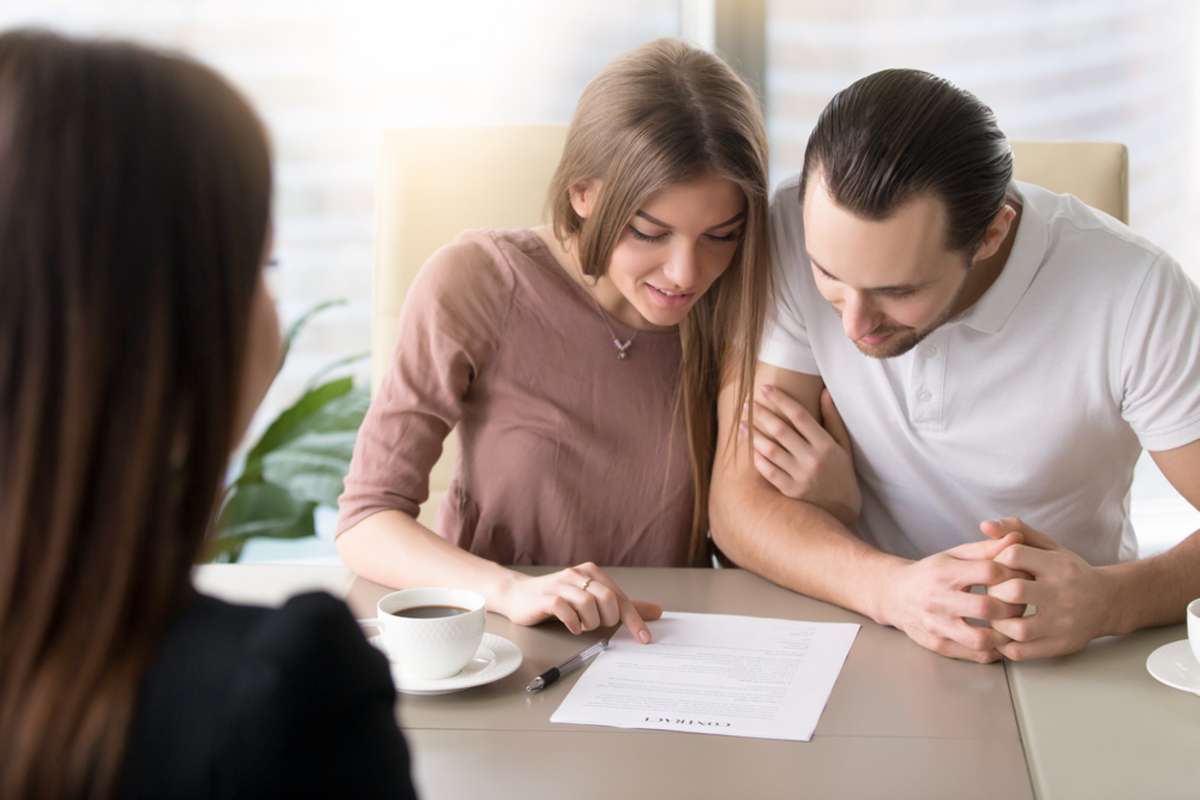 Smiling family couple reading contractual terms