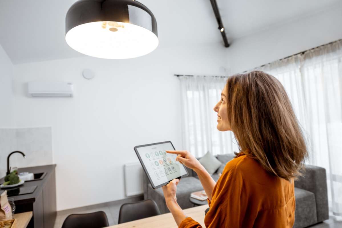 Young woman controlling home light with a digital tablet (R) (S)