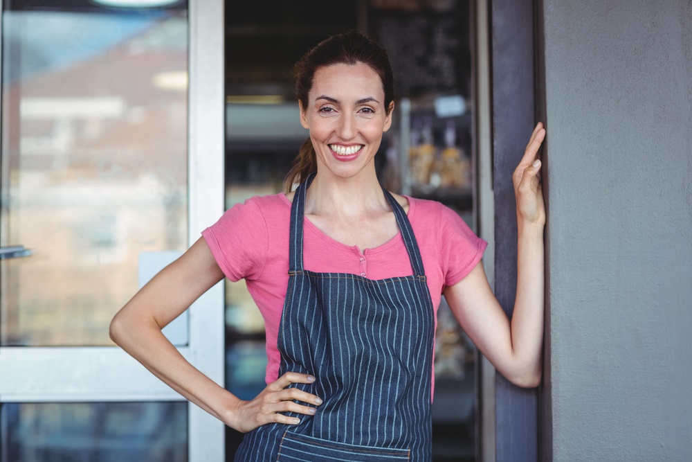 Pretty waitress leaning on the wall at the bakery