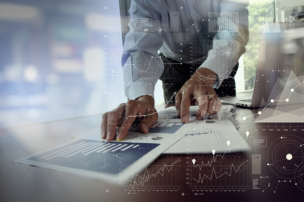 close up of businessman hand working on laptop computer with financial business graph information diagram on wooden desk as concept-2