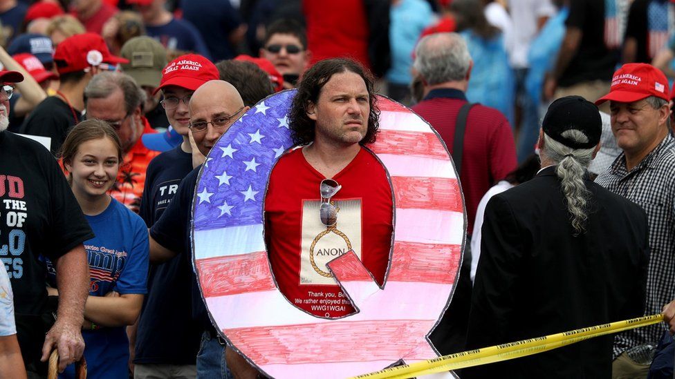 Man at rally with QAnon sign