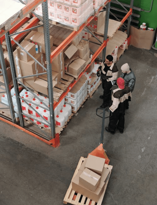 Trois personnes dans un entrepôt vue du haut