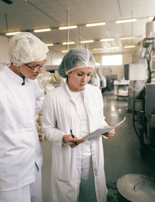 Deux personnes en blouses regardant une feuille