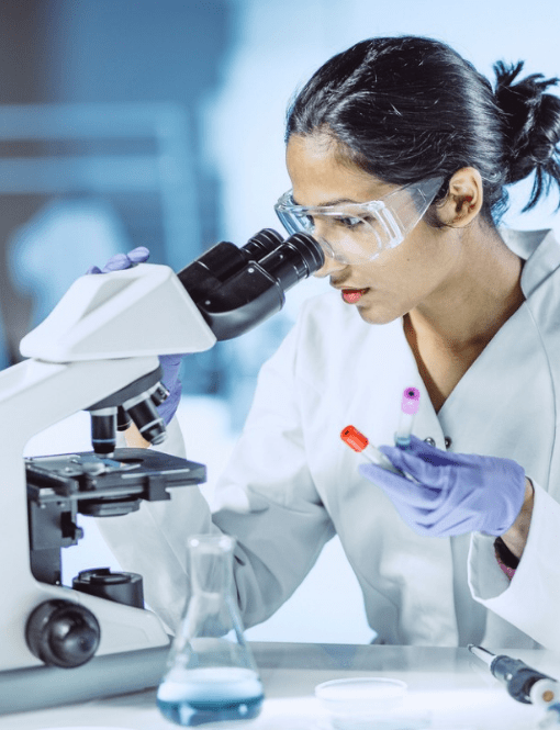 Une chimiste regardant dans un microscope